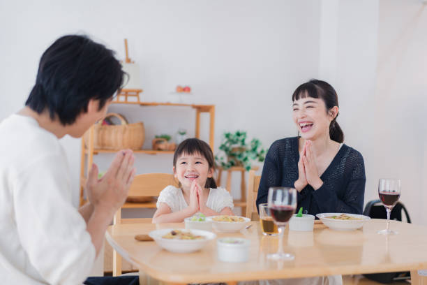 ダイニングルームでランチを食べる家族 - 家族全員でくつろぐ様子 ストックフォトと画像