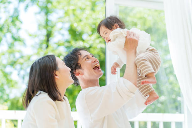 赤ちゃんとくつろぐ若い親のポートレート - 3人の子どもと過ごす育休中の様子 ストックフォトと画像